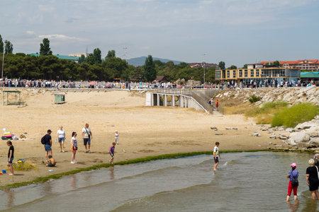 July 30, 2023, Republic of Dagestan, Kaspiysk, Navy Day, parade of ships decorated with flags, spectators watch from the rocky shore.のeditorial素材