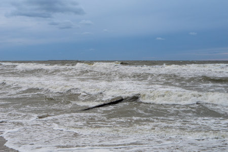seashore on a cloudy day, strong waves, storm on the horizon, dark blue sky. horizontal photoの写真素材