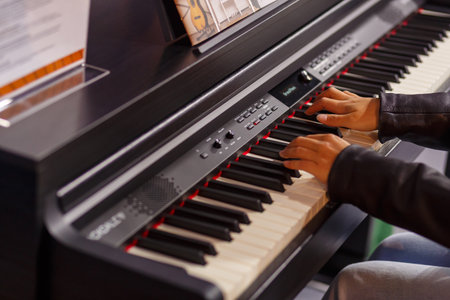 A musician's hands test a piano at an exhibition of musical instruments. horizontal photoの写真素材