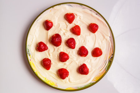Fresh juicy red strawberries in whipped cream in a plate on the table. horizontal photoの写真素材
