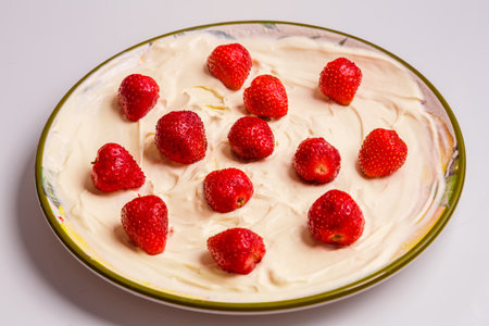 Fresh juicy strawberries in whipped cream in a plate on the table. horizontal photoの写真素材