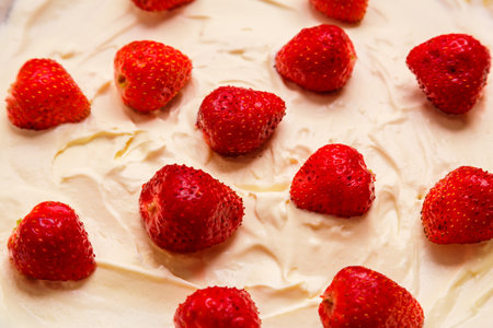 Fresh juicy red strawberries with green leaves in thick whipped cream close-up. horizontal photoの写真素材