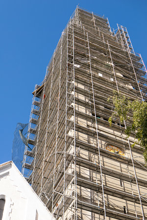 Reconstruction of the facade of a high-rise building scaffolding. Vertical photo.