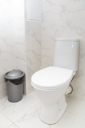 White toilet against a white wall in the bathroom. Vertical photo.の写真素材