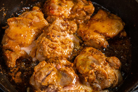 Chicken pieces in soy sauce and spices are fried in a frying pan. horizontal photoの写真素材
