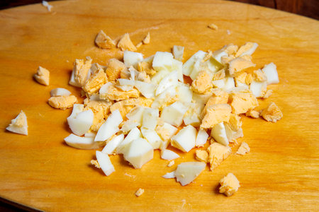 Finely chopped egg on a wooden board on the table. Horizontal photo.の写真素材