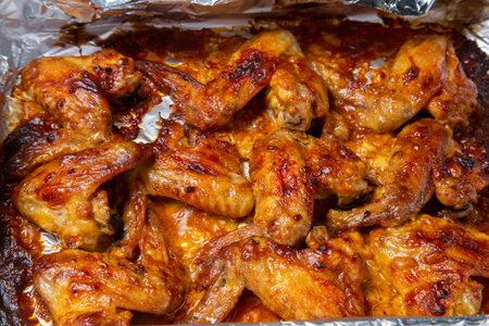 Chicken wings baked in soy and garlic marinade with a crispy crust on foil. Horizontal photo.の写真素材