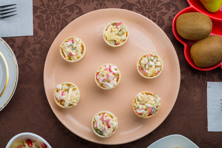 Throwing forks on the table set with salad in tartlets, fruit snacks. Horizontal photo.の写真素材