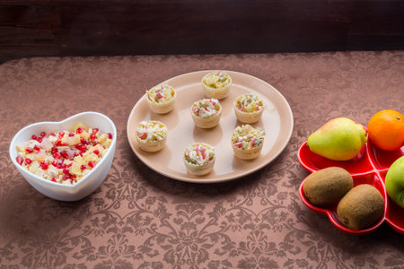 Throwing forks on the table set with salad in tartlets, fruit snacks. Horizontal photo.の写真素材