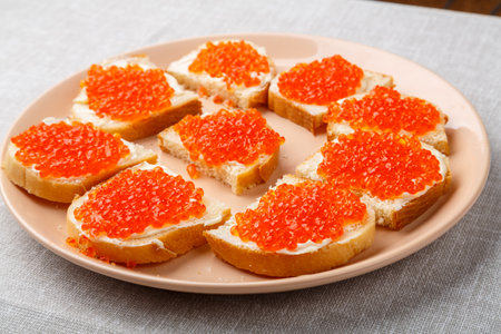 Sandwiches with red caviar on a table on a white tablecloth close-up. horizontal photoの写真素材