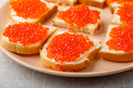 Sandwiches with red caviar on a table on a white tablecloth close-up. horizontal photoの写真素材