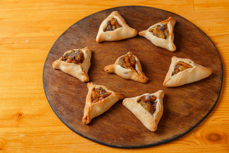 Sweet gomentashi cookies on a wooden board in the shape of a Star of David for a Purim treat. Horizontal photo.の写真素材