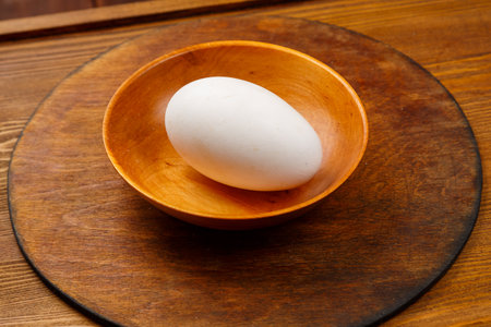 goose egg in a wooden plate on the table. Horizontal photo.の写真素材