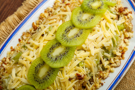 Chicken salad decorated with kiwi and nuts and Thai chicken fragment of a plate. horizontal photo