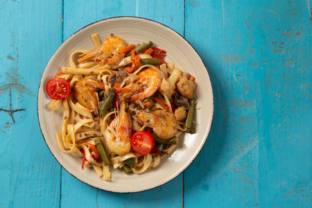 shrimp and udon vegetables pad thai sauce and chopsticks for and on the table. .Horizontal photoの写真素材