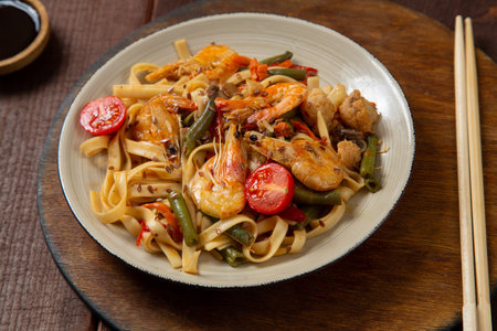 shrimp and udon vegetables pad thai sauce and chopsticks for and on the table. .Horizontal photoの写真素材