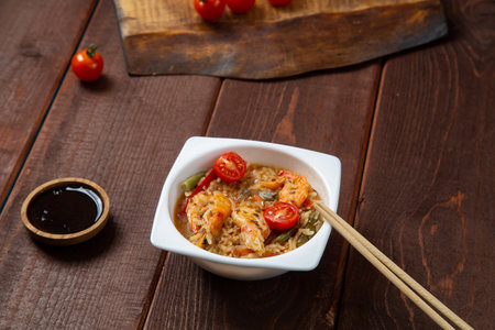 shrimp and rice yaki soba sauce next to cherry tomatoes soy sauce and chopsticks. horizontal photoの写真素材