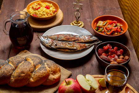 Hala, honey, apple and grenades and wine of the Chelnt and fish on the table with menora and burning...