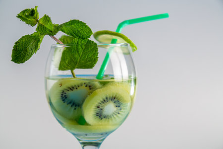 Non-alcoholic cocktail kiwi lime and mint in a glass with a straw on a wooden table. horizontal photoの写真素材