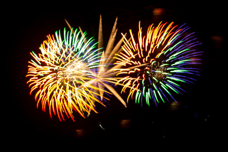 Multicolored and golden sparks of fireworks on the black sky. Horizontal photo.の写真素材