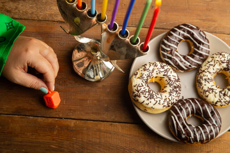 A woman's hand spins a dreidel at the Hanukkah table. Horizontal photo.の写真素材