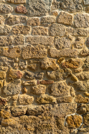 Ancient stone gray wall of the fortress uneven rough texture. Vertical photo.の写真素材