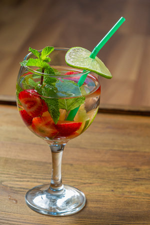 Non-alcoholic cocktail strawberry kiwi lime in a glass on a wooden table. Vertical photoの写真素材