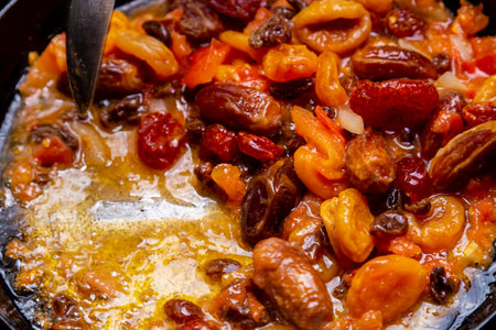 Red beans in tomato sauce with dried fruits stewed in a frying pan. Horizontal photo.の写真素材