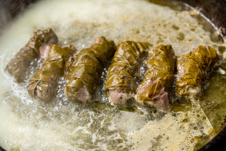 Dolma grape leaves with beef in a frying pan with oil stewed in water. Horizontal photo.の写真素材