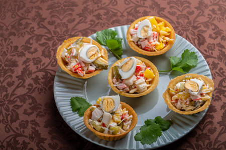 Salad with pineapples and tarts on a plate decorated with cilantro on a brown tablecloth. Horizontal photo.の写真素材