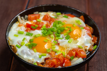 Shakshuka dish of eggs with tomatoes and green onions. Horizontal photo.の写真素材