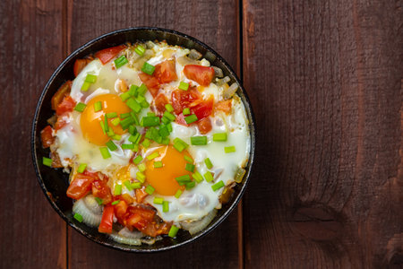 Shakshuka dish with egg, tomatoes and green onions. Copy space. Horizontal photo.の写真素材