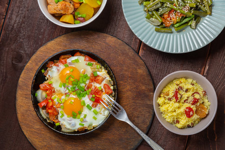 Jewish food tzimmes, chelnt, shakshuka for the holiday next to a fork. Horizontal photo.の写真素材