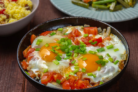 Shakshuka dish of eggs with tomatoes and green onions. Horizontal photo.の写真素材