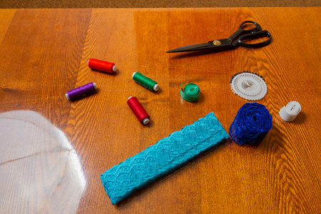 Sewing and knitting threads, knitting needles, measuring tape and scissors on the table in the room...