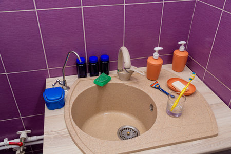 The bathroom sink is next to soap, shampoo and other accessories. Horizontal photo.の写真素材