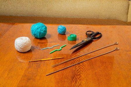 Sewing and knitting threads, knitting needles, measuring tape and scissors on the table in the room Horizontal photo.の写真素材