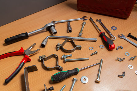 On the table in the workshop are screwdrivers, wrenches, pliers, nuts, bolts and other tools. Horizontal photo.の写真素材