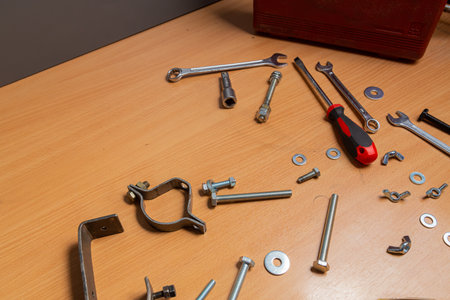 On the table in the workshop are screwdrivers, wrenches, pliers, nuts, bolts and other tools....
