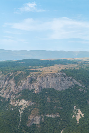 Mountain ranges covered with green vegetation on a sunny day.の写真素材