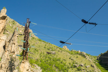 Power lines and towers in the mountains high up. Horizontal photo.の写真素材