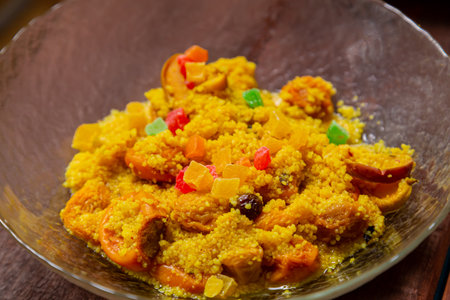 Steamed couscous with dried fruits, nuts, and turmeric in a transparent bowl. Horizontal photo.の写真素材