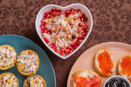 Chicken salad, salad in tartlets, canap s with red caviar, trout, and olives on a plate, fragments...