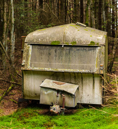 An abandoned caravan in the middle of the woods.の写真素材
