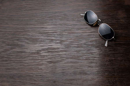 Sunglasses on a dark wooden table.の写真素材