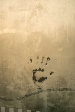 A steamed up window with a hand mark.の写真素材