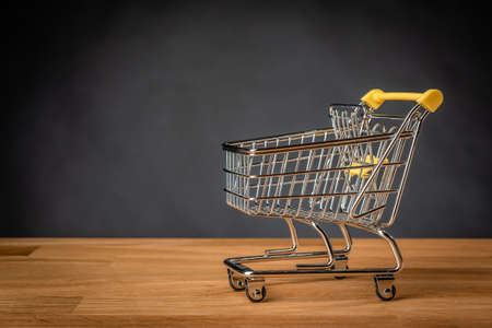 Empty shopping cart on wooden table.の写真素材