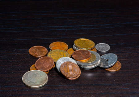 Different kinds of coins on a black table.