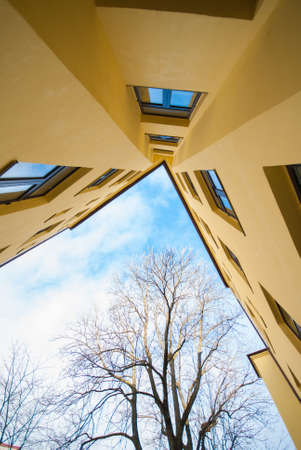 Looking up a yellow apartment building.の写真素材