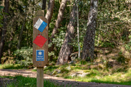 Swedish sign stating naturreservat, meaning nature reserve. Forest in the background.